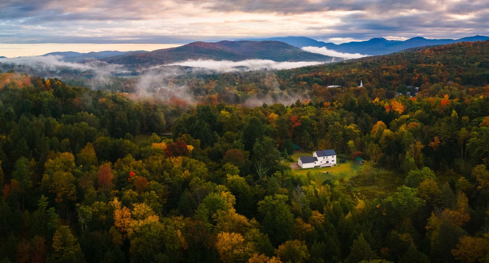 Peak fall foliage across a Vermont hillside
